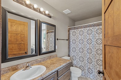 Full bath featuring vanity, a shower with shower curtain, and a textured ceiling