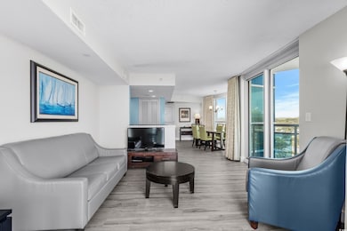 Living room with a chandelier, light hardwood / wood-style flooring, and a textured ceiling