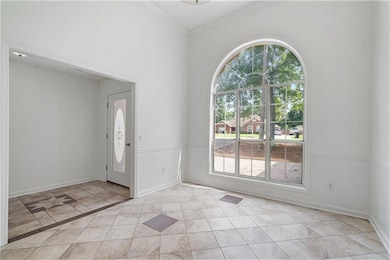 Dining room with crown molding and light tile patterned flooring