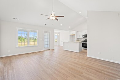 Unfurnished living room with high vaulted ceiling, a ceiling fan, light wood finished floors, a chandelier, and recessed lighting