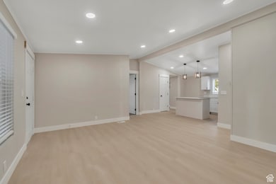 Unfurnished living room with light wood-style floors, recessed lighting, and vaulted ceiling
