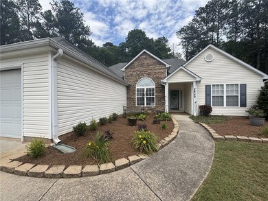 View of front facade with stone siding, a garage, and a shingled roof