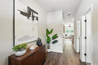 Hallway with wood finished floors, a desk, and recessed lighting
