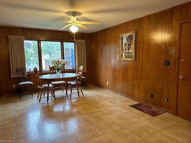 Dining room featuring wood walls, light tile flooring, and ceiling fan