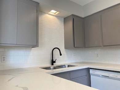 Modern kitchen with gray cabinets, white subway ti