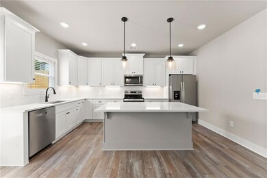 Kitchen featuring stainless steel appliances, backsplash, light countertops, and recessed lighting