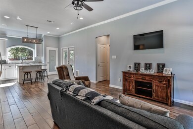 Living room featuring ceiling fan, crown molding, 