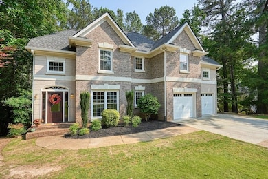 View of front of home featuring driveway, a garage, a front yard, and brick siding