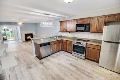 Kitchen featuring a brick fireplace, a sink, appli