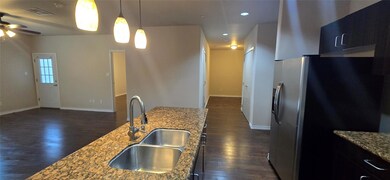 Kitchen featuring dark wood-type flooring, stainle