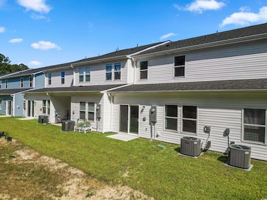 Back of property with cooling unit and a yard