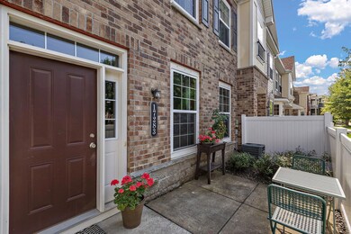 The front door with the main floor living room windows that overlook this intimate patio.