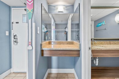 Bathroom with tile patterned flooring, a paneled c
