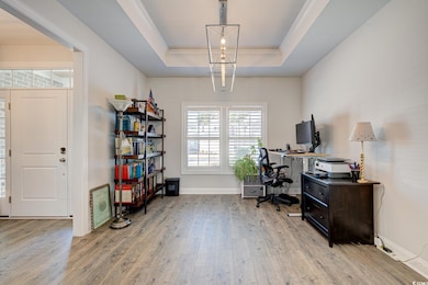 Office featuring light wood-style floors, a raised