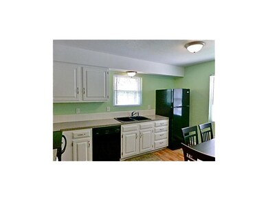 Fresh, bright kitchen with black appliances and wo