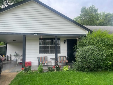 Rear view of house featuring covered porch and an attached carport