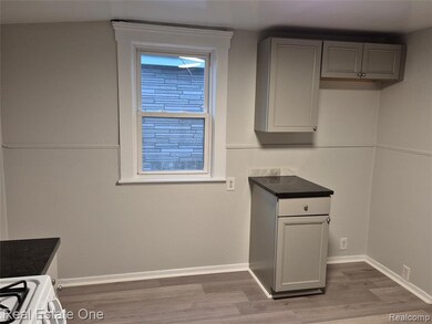 Kitchen with gray cabinetry, white gas stove, and light wood-style floors