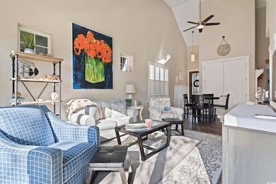 Living area featuring high vaulted ceiling, a ceiling fan, and light wood-style flooring