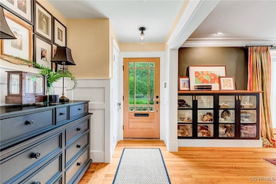 Entryway featuring light wood floors and a wainsco