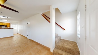Staircase with a ceiling fan and baseboards