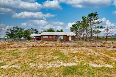 Back of house with brick siding and fence