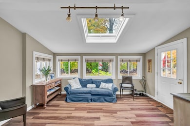 Enter main level through bright Sunroom with new skylight and luxury vinyl flooring.