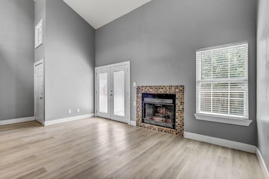 Unfurnished living room featuring high vaulted ce
