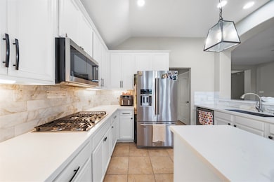 The Kitchen features white cabinetry, stainless st