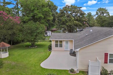 Back of property with a lawn, a storage unit, and 