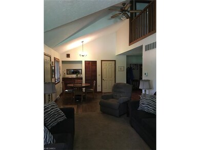 Vaulted living room and dining area with views of 