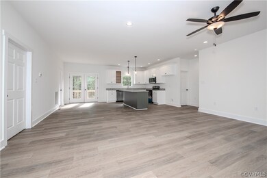 The living room featuring ceiling fan, french door