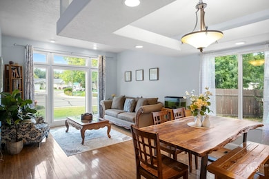 Dining area featuring healthy amount of natural light, wood-type flooring, a raised ceiling,
