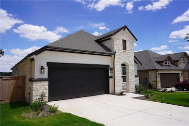 French country home featuring stone siding, roof 