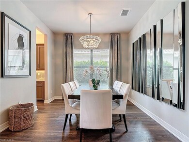 Dining area with a chandelier and dark wood-type flooring