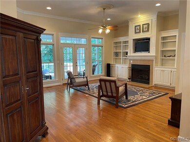 Living room with surround sound, fireplace, french doors, light hardwood flooring, and ceiling fan