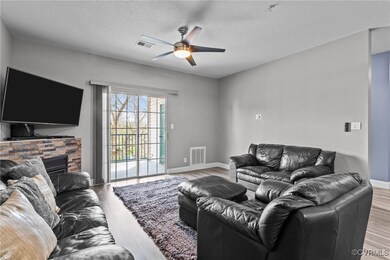 Living area with baseboards, ceiling fan, visible vents, and wood finished floors