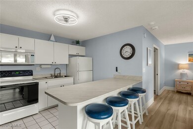 Kitchen featuring white appliances, a sink, white