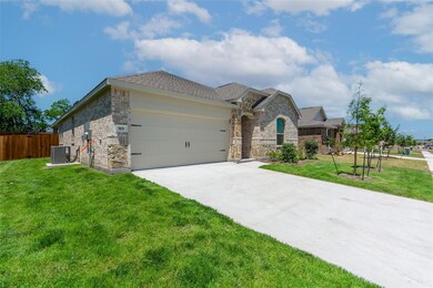 View of front of house featuring a garage, central air condition unit, and a front lawn