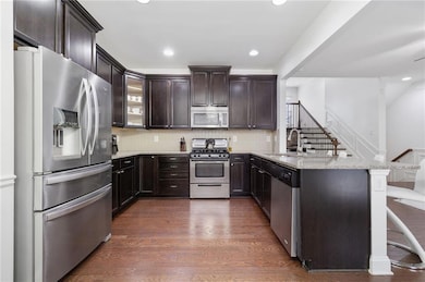 Kitchen with dark wood-type flooring, a sink, appl