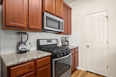 Kitchen with backsplash, light stone counters, li