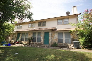 View of front facade featuring a chimney, stone siding, and a front lawn