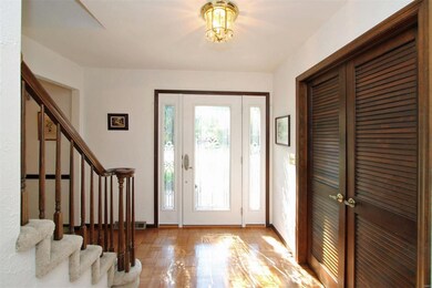 Large, open, airy foyer with parquet flooring