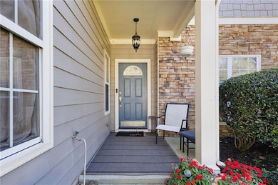 View of exterior entry featuring a porch and stone siding