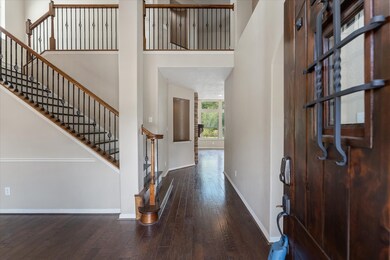  Two-story foyer featuring a staircase with wrought iron spindles.