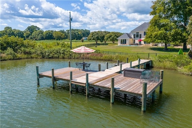 Dock area with a water view and view of scattered trees
