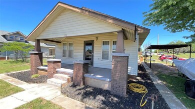 View of front facade with covered porch and a carport