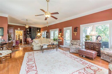 Living room featuring ceiling fan, crown molding, 