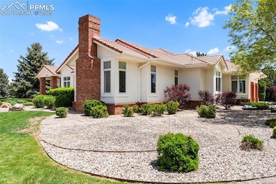 View of home's exterior with a chimney, a tiled roof, and stucco siding