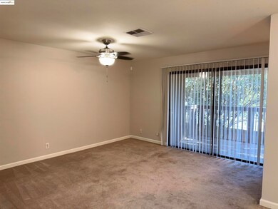 Living room with light colored carpet and a ceiling fan