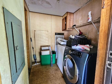 Laundry room with separate washer and dryer, cabinet space, a textured ceiling, and tile patterned floors